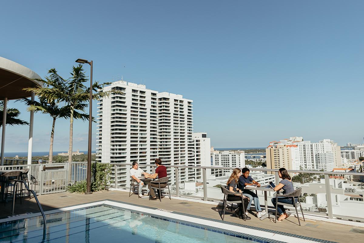 community development students sitting at tables on the rooftop of a building